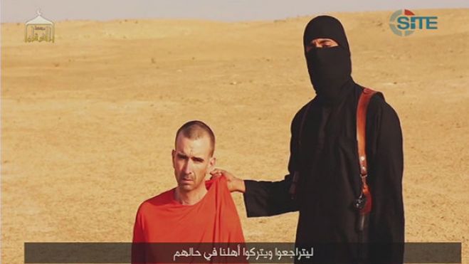 Encapuzado, o terrorista de cidadania britânica apelidado de &#039;John&#039; é visto ao lado do refém David Haines, o terceiro estrangeiro decapitado pelo Estado Islâmico (EI) na Síria